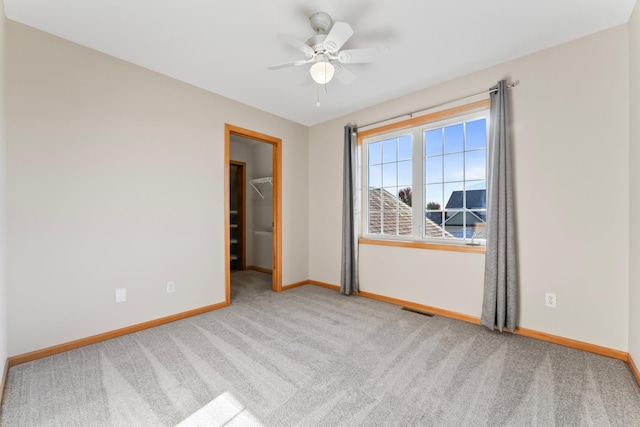 carpeted spare room featuring ceiling fan