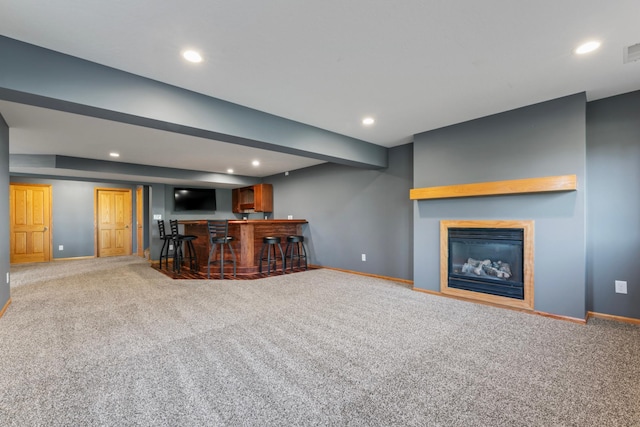 unfurnished living room featuring indoor bar and carpet