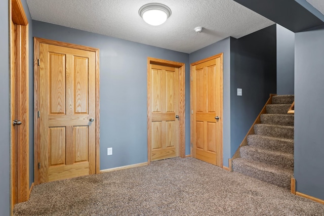 interior space with a textured ceiling and carpet floors