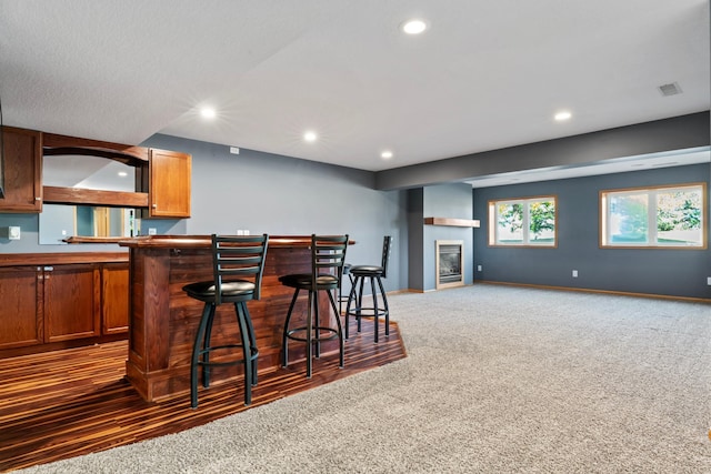 kitchen featuring a breakfast bar and dark carpet