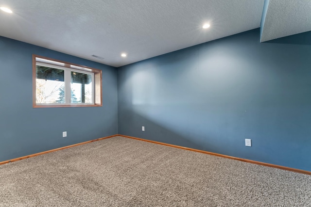 carpeted empty room featuring a textured ceiling