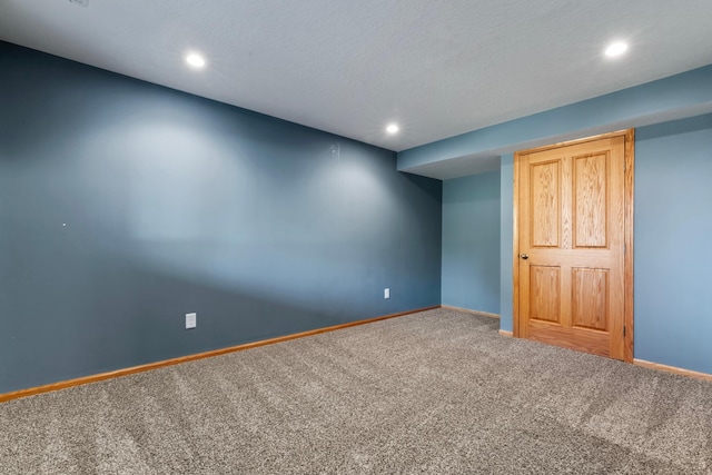 carpeted empty room with a textured ceiling