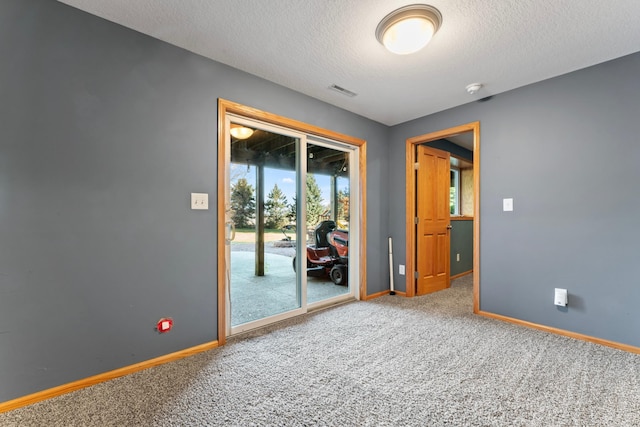 spare room with a textured ceiling and carpet flooring