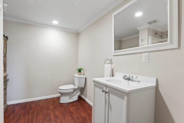 bathroom with vanity, toilet, crown molding, and hardwood / wood-style floors