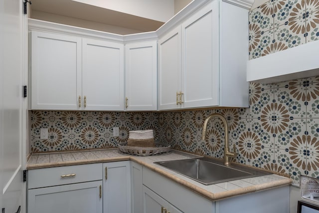 kitchen with backsplash, sink, and white cabinets