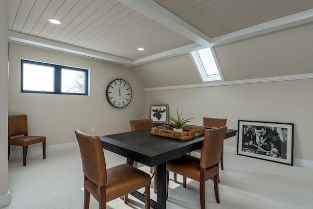 carpeted dining room with vaulted ceiling with skylight and wooden ceiling