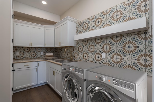 clothes washing area featuring cabinets, sink, independent washer and dryer, and dark hardwood / wood-style floors