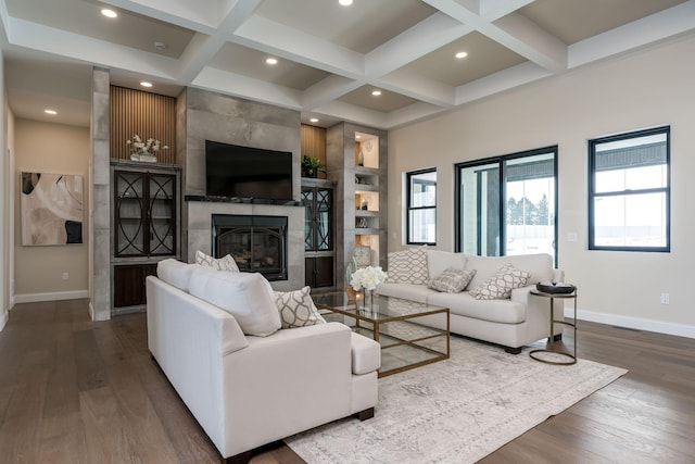 living room featuring hardwood / wood-style flooring, coffered ceiling, a large fireplace, and beam ceiling