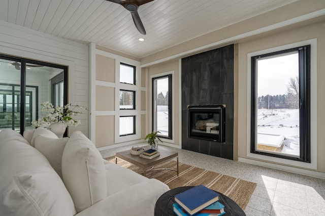 living room featuring ceiling fan, wood ceiling, and a fireplace