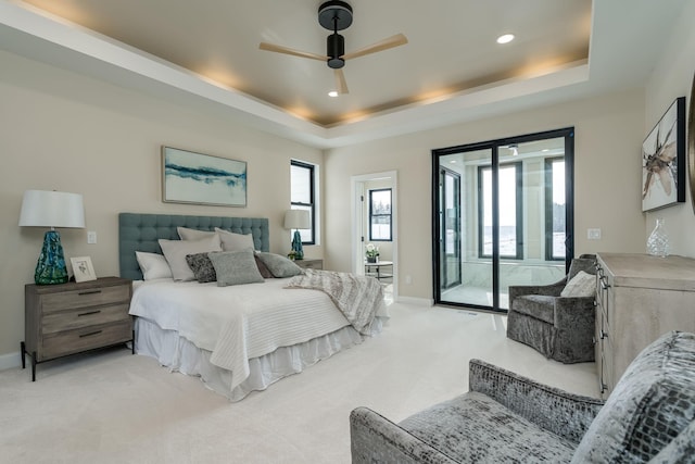 bedroom with access to outside, light colored carpet, ceiling fan, and a tray ceiling