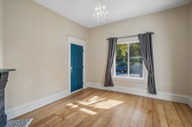 empty room featuring hardwood / wood-style flooring and a chandelier