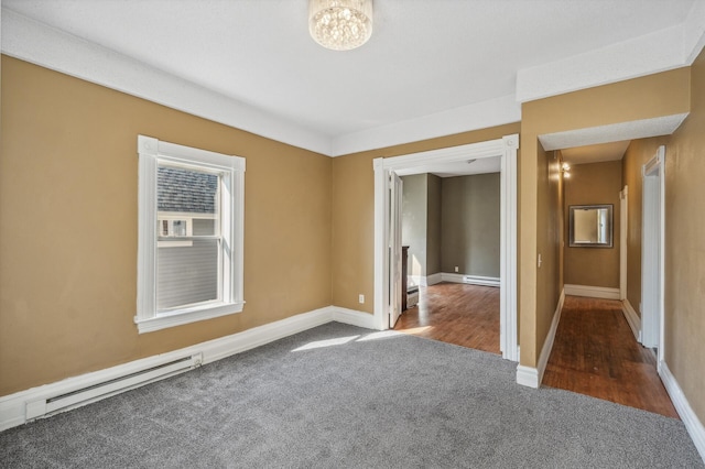 carpeted empty room with a baseboard heating unit