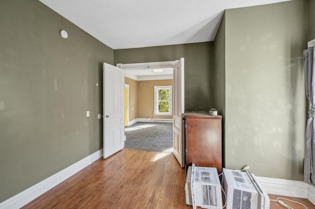 corridor with light hardwood / wood-style floors and a textured ceiling