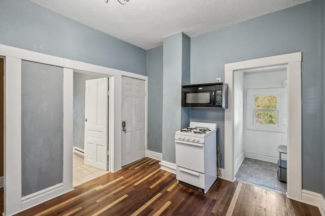 kitchen featuring white gas range oven, dark hardwood / wood-style floors, and a textured ceiling