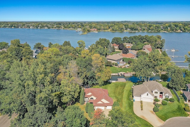 aerial view featuring a forest view, a residential view, and a water view