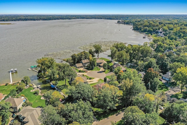 drone / aerial view with a forest view, a water view, and a residential view