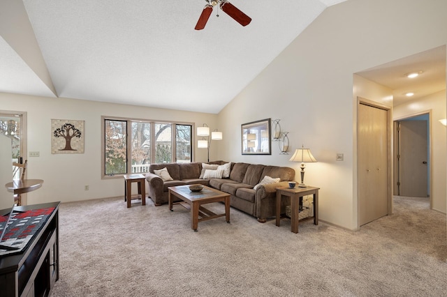 living room featuring ceiling fan, high vaulted ceiling, and light carpet