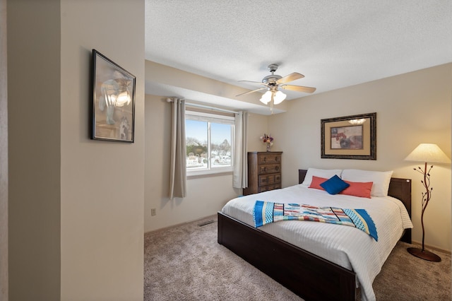 carpeted bedroom featuring a ceiling fan, baseboards, and a textured ceiling