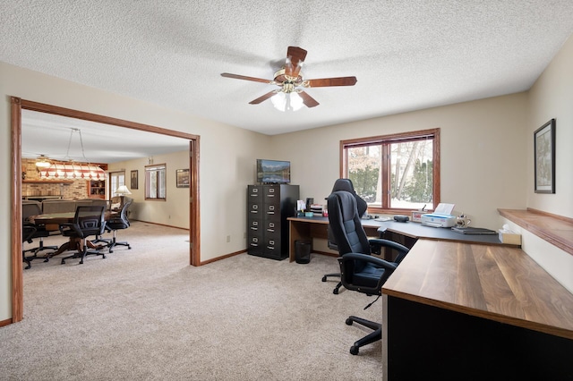 office area with baseboards, a textured ceiling, ceiling fan, and carpet flooring