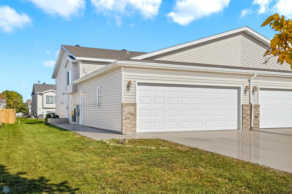 view of property exterior featuring a garage and a lawn