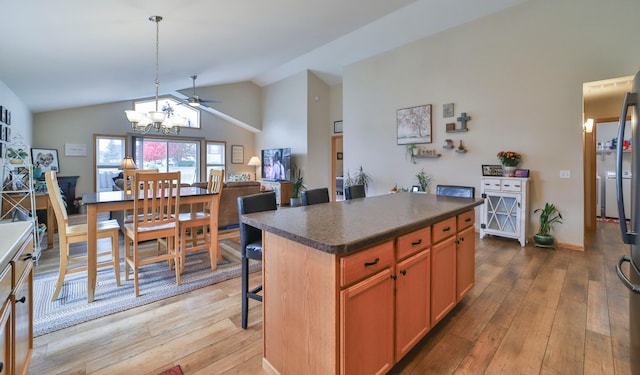 kitchen with lofted ceiling, wood-type flooring, a kitchen breakfast bar, and a kitchen island