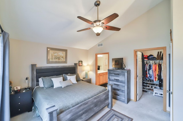 carpeted bedroom featuring lofted ceiling, a spacious closet, ceiling fan, ensuite bath, and a closet