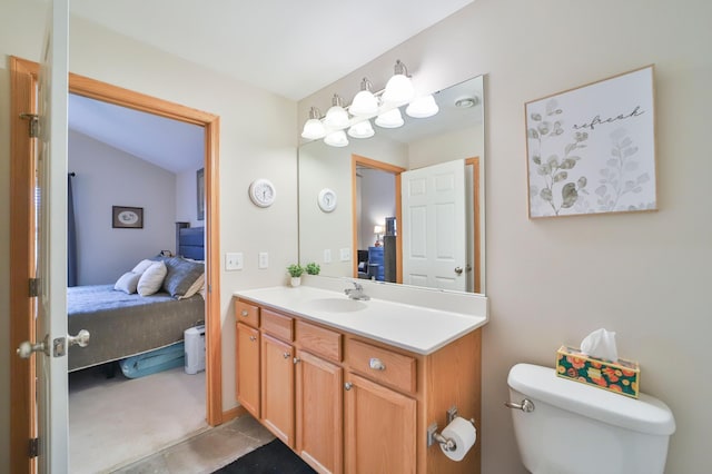 bathroom with vanity, toilet, and vaulted ceiling