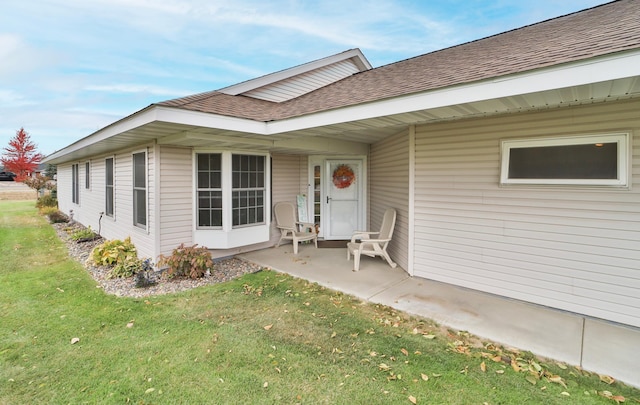 property entrance with a yard and a patio