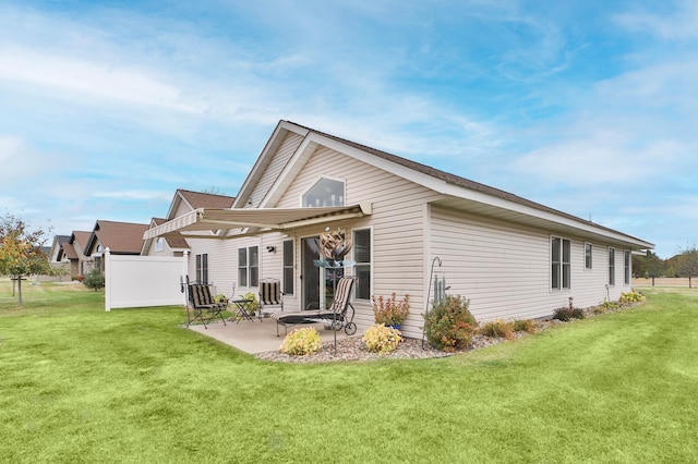 back of house featuring a lawn and a patio