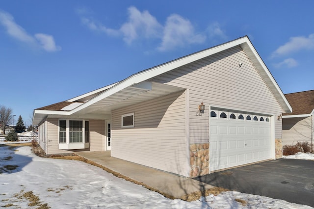 view of snowy exterior with a garage and a porch