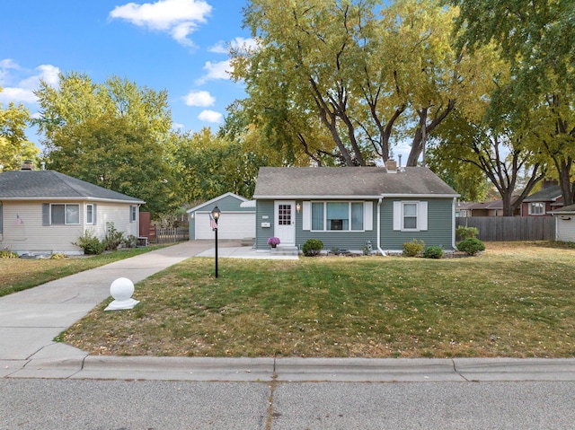 ranch-style house with an outbuilding, fence, a front yard, a garage, and a chimney