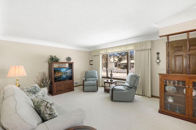 living area with visible vents, baseboards, and carpet floors