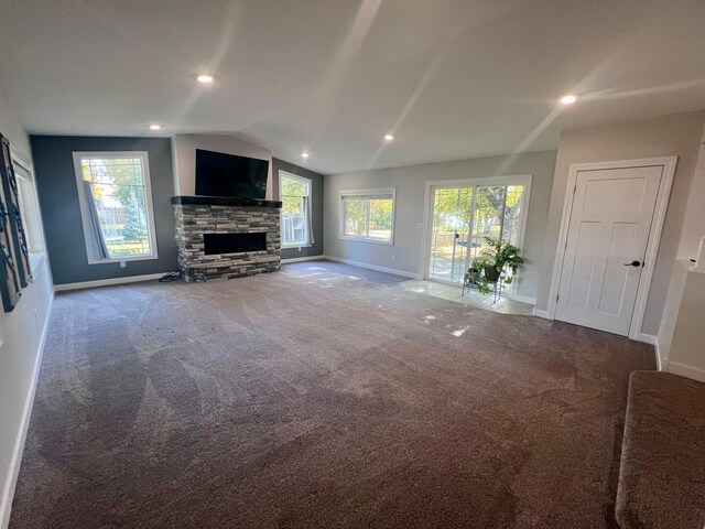 712 11th St, Montevideo, MN 56265 - unfurnished living room with a stone fireplace, carpet, lofted ceiling, and baseboards