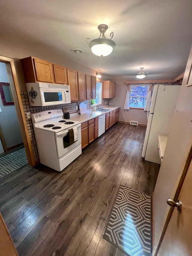 kitchen featuring dark hardwood / wood-style floors, white appliances, and decorative backsplash