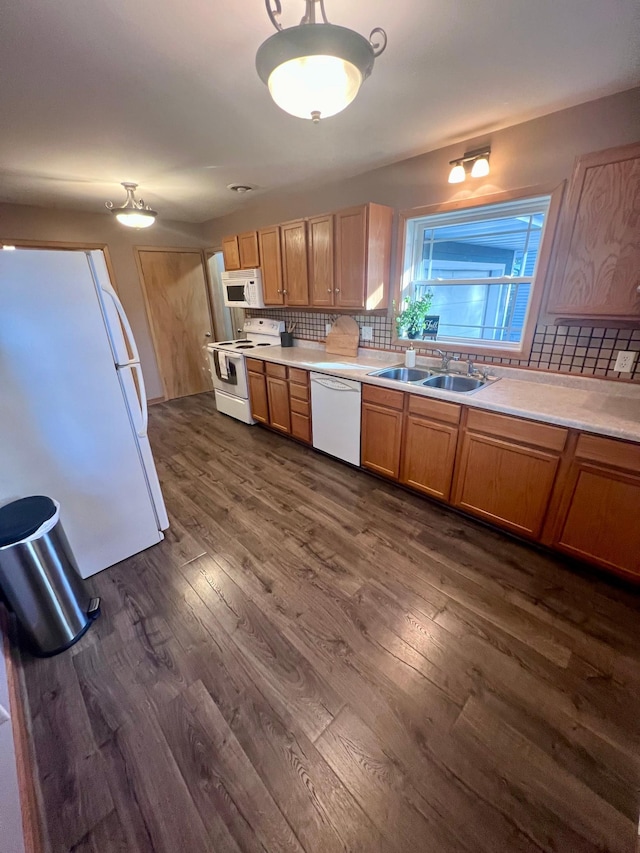 kitchen featuring tasteful backsplash, white appliances, sink, and dark hardwood / wood-style flooring