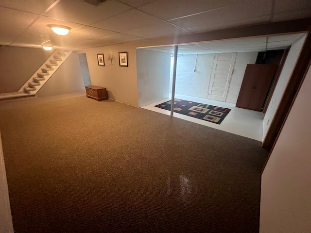 basement featuring a paneled ceiling and carpet flooring