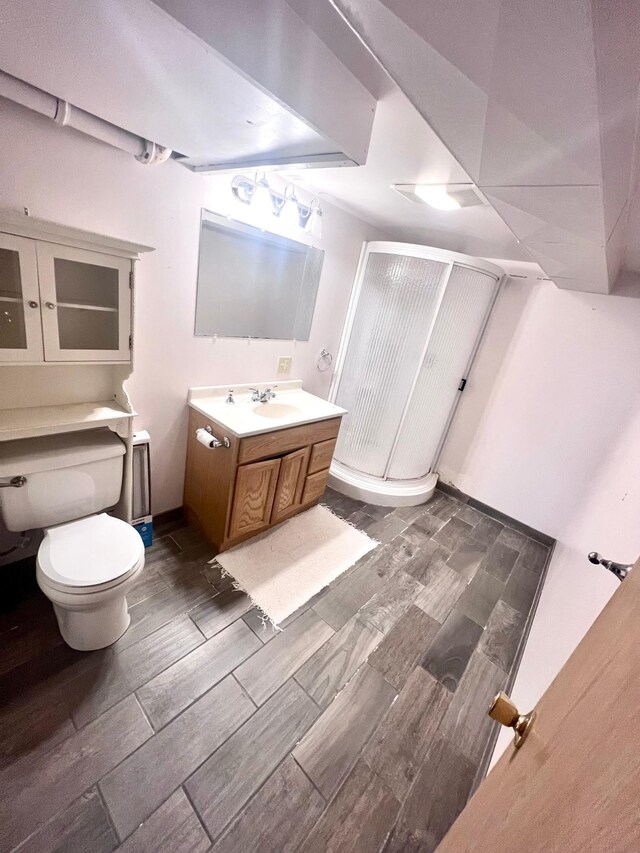 712 11th St, Montevideo, MN 56265 - bathroom with vanity, wood tiled floor, a stall shower, and toilet