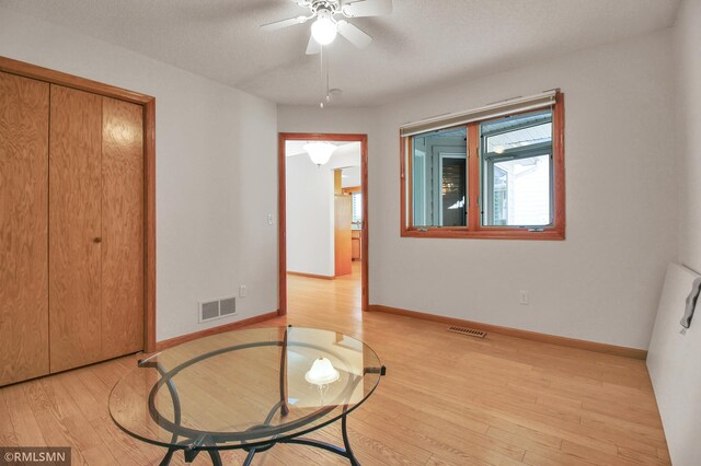 interior space featuring a textured ceiling, ceiling fan, and light hardwood / wood-style flooring