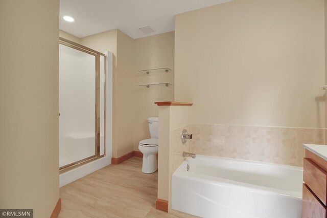 full bathroom with hardwood / wood-style flooring, vanity, toilet, and shower with separate bathtub