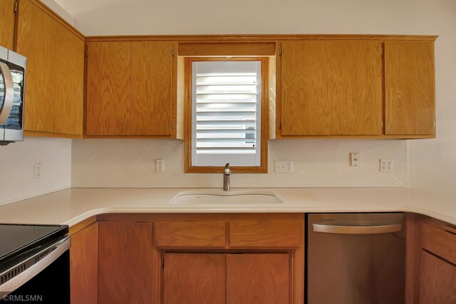 kitchen with stainless steel appliances, backsplash, and sink