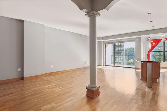 interior space with light hardwood / wood-style flooring and ornate columns