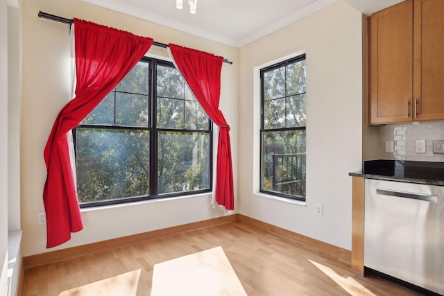 unfurnished dining area featuring crown molding and light hardwood / wood-style flooring