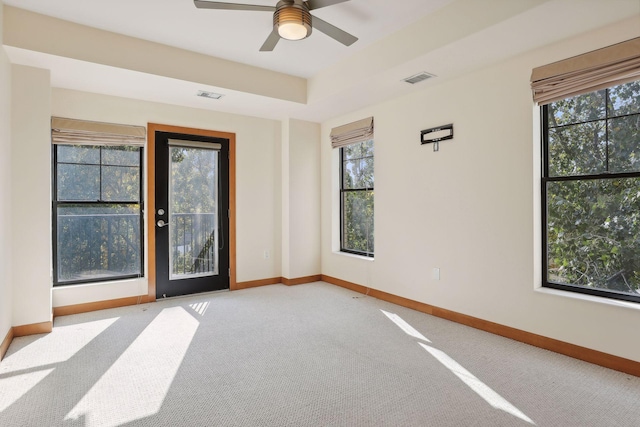 carpeted empty room featuring a healthy amount of sunlight and ceiling fan