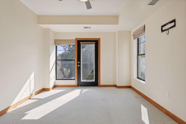 carpeted empty room featuring ceiling fan and a wealth of natural light