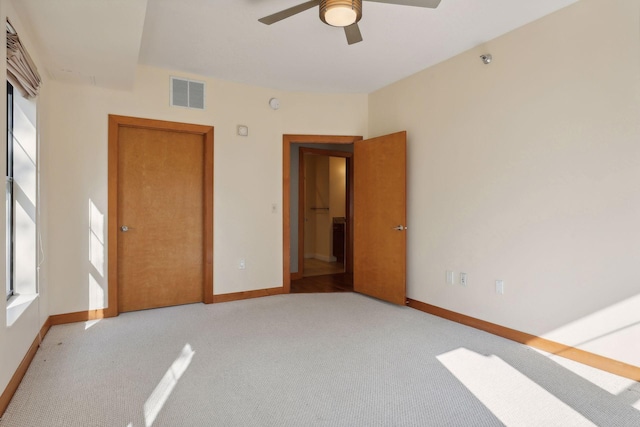 unfurnished bedroom with light colored carpet and ceiling fan