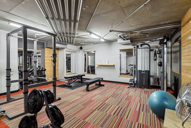 workout area with carpet floors and wooden walls