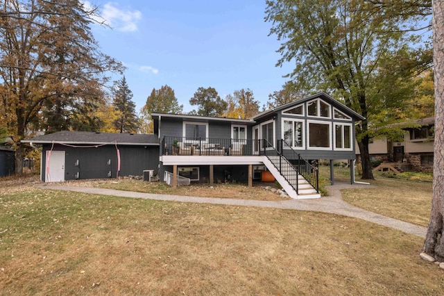 back of house featuring a sunroom, a lawn, and central AC