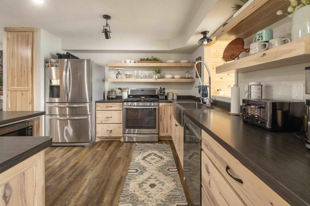 kitchen featuring dark wood-type flooring, light brown cabinets, sink, appliances with stainless steel finishes, and a textured ceiling