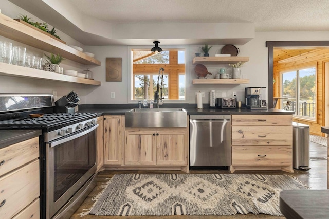 kitchen featuring wooden walls, dark hardwood / wood-style flooring, appliances with stainless steel finishes, light brown cabinetry, and a textured ceiling