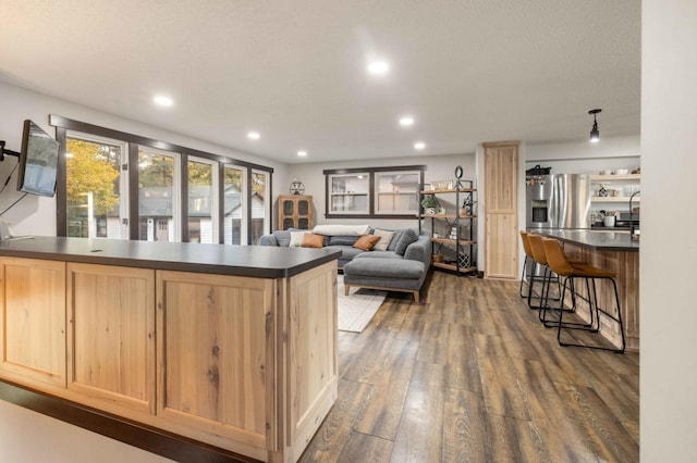 kitchen with light brown cabinetry, stainless steel refrigerator with ice dispenser, and dark hardwood / wood-style flooring